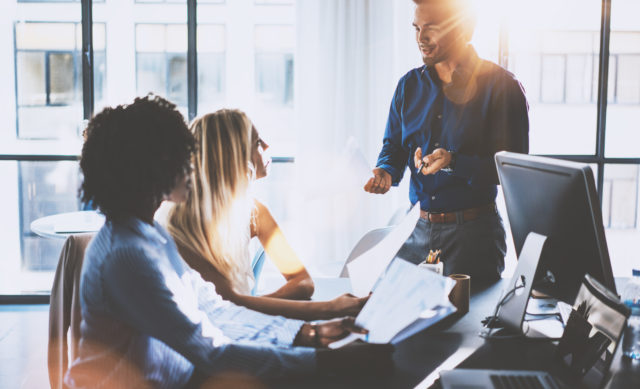Young team of coworkers making great meeting discussion in modern