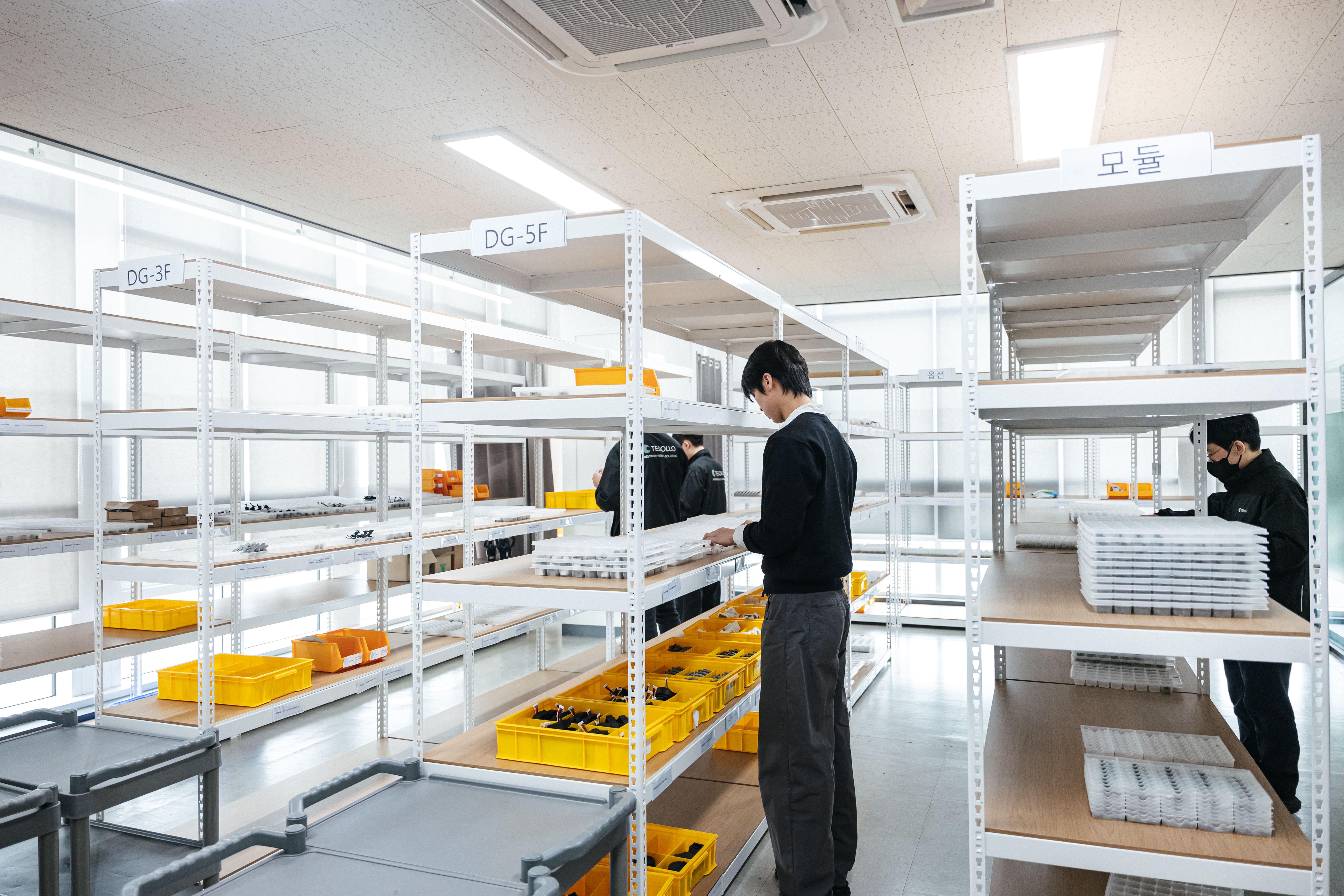 테솔로 직원들이 창고에서 부품을 검수 중이다.
