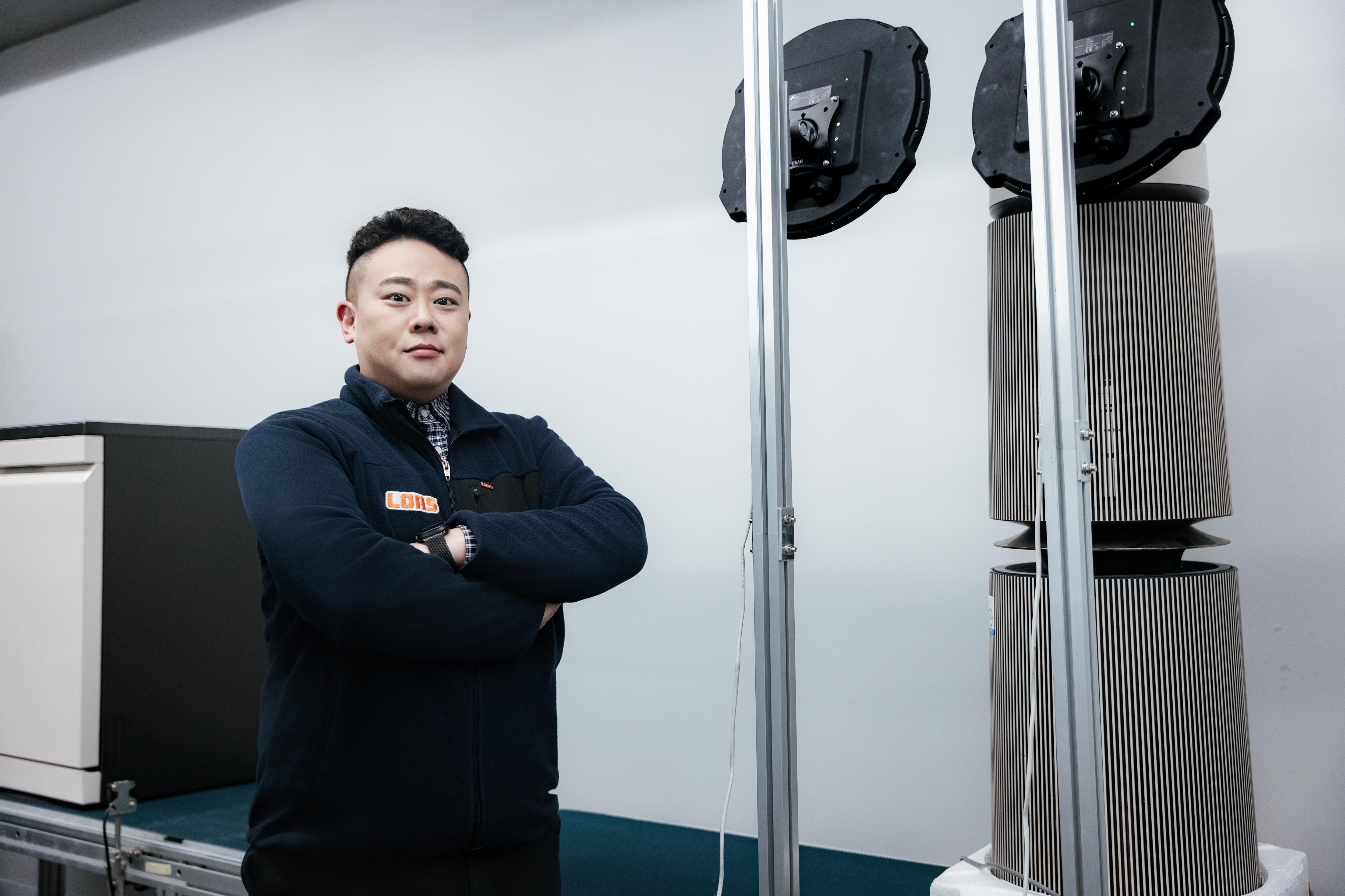 로아스의 이재현 대표가 제조 공정용 음향 탐지 장비 앞에서 팔짱을 끼고 서 있다.