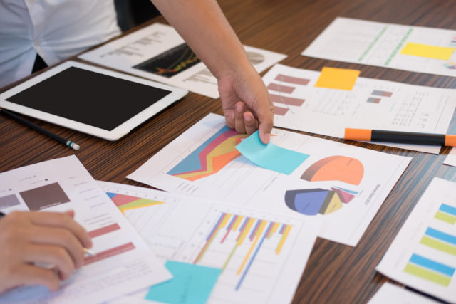 young successful startup team on meeting in office. businessman & businesswoman brainstorm, make a business plan, work on tablet with financial and marketing graph and chart