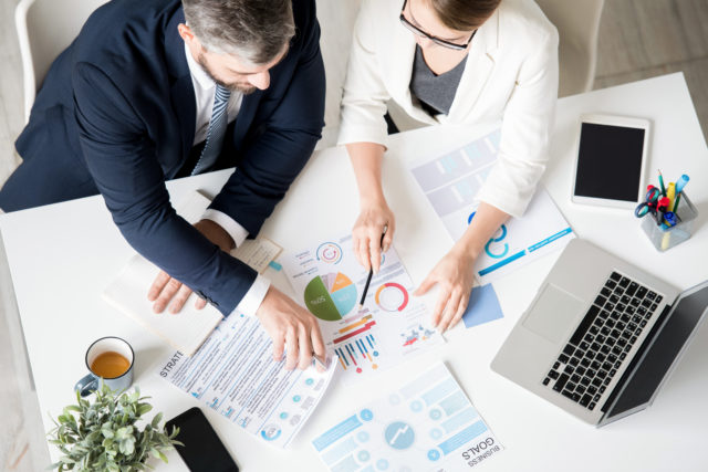 Business specialists analyzing progress while viewing charts