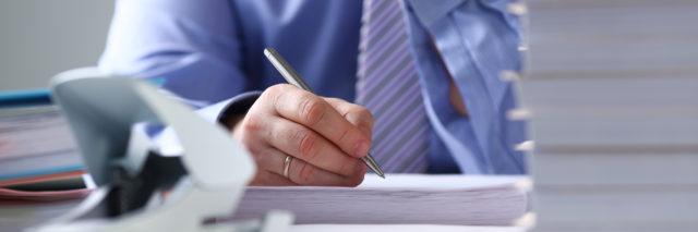 Arm fill and sign important form clipped to pad with silver pen