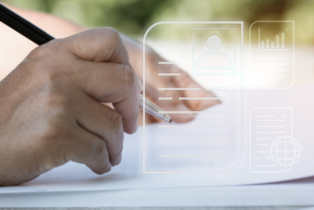 Document Report and business data system business HR technology Concept: Businessman Manager hands holding pen for checking and signing white documents reports papers of files icon in modern office